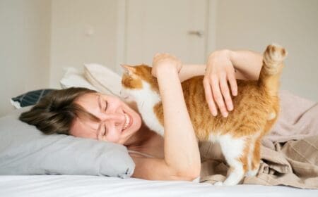 woman smiling cuddling cat